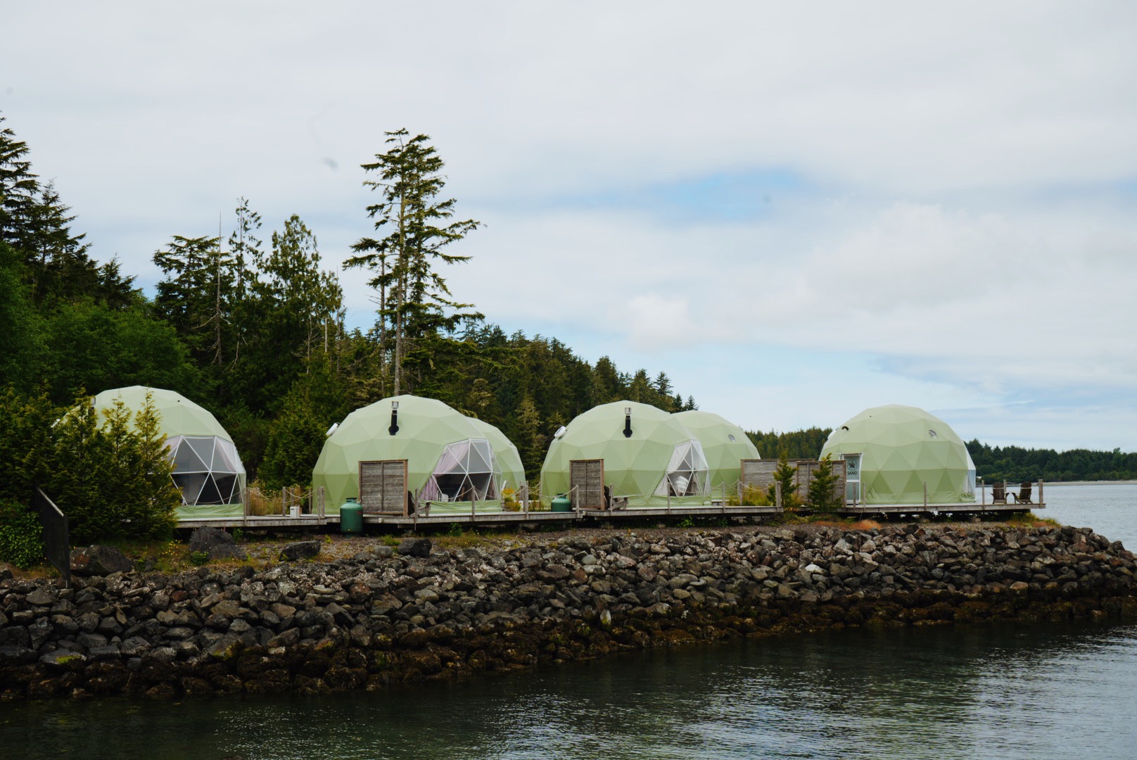 Row of Wildpods domes along the rocky shoreline